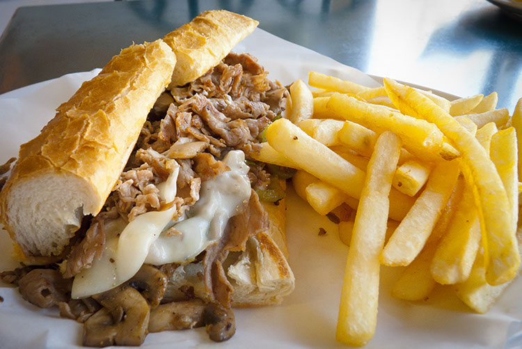 This Provolone cheese steak is busting at the seams. Even the fries can't keep their hands off it.